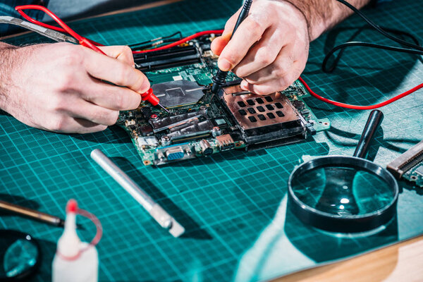 Close-up view of male engineer testing circuit board