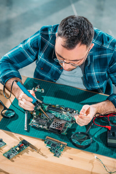 Top view of engineer in glasses working with pc parts