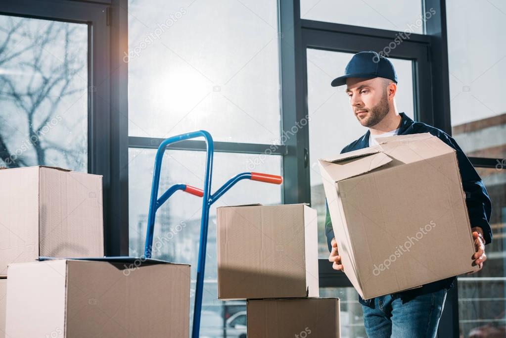 Delivery man stacking boxes on cart