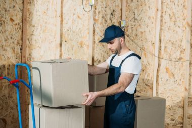 Delivery man stacking boxes on cart clipart