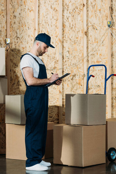 Loader man filling cargo declaration by delivery cart