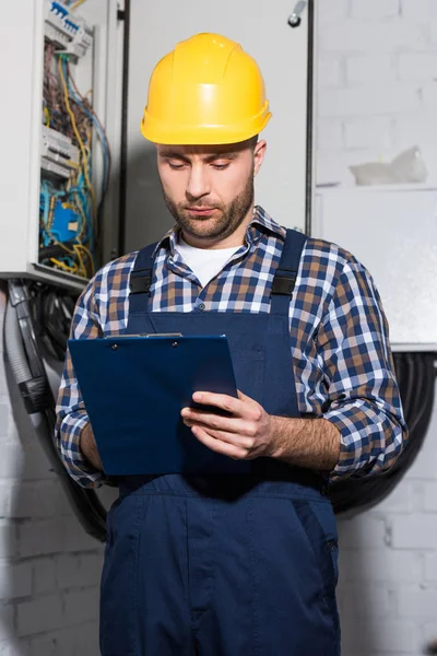 Elektriker Füllt Checkliste Für Die Wartung Von Stromleitungen Aus — Stockfoto