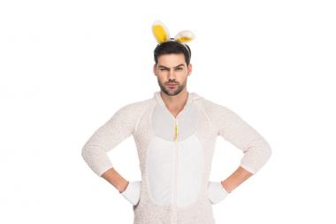 Man in rabbit costume shutting one eye and holding arms on thighs isolated on white, easter concept clipart