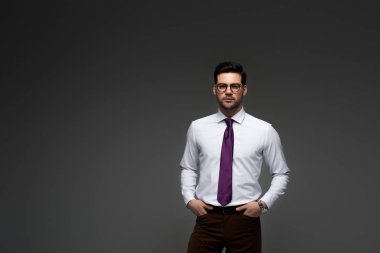 İşadamı ile parmak gri izole ceplerinde duran gözlük