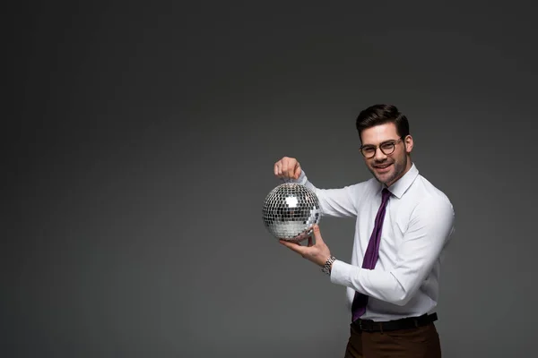 Стильный Бизнесмен Показывает Стеклянный Диско Мяч Изолирован Серый — стоковое фото