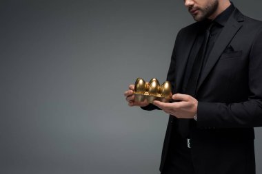 Grey, Paskalya kavramı izole erkek holding altın yumurta kırpılmış görüntü