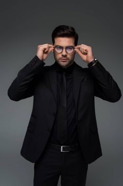 Gözlük gri izole kapalı alarak şık siyah elbiseli adam 