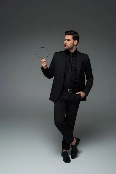 Stylish Man Black Suit Posing Glasses Hand Grey — Stock Photo, Image