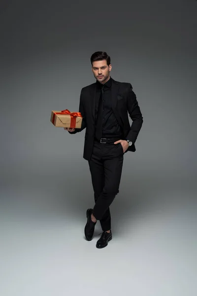 Man Formal Black Suit Holding Gift Box Grey International Womens — Stock Photo, Image