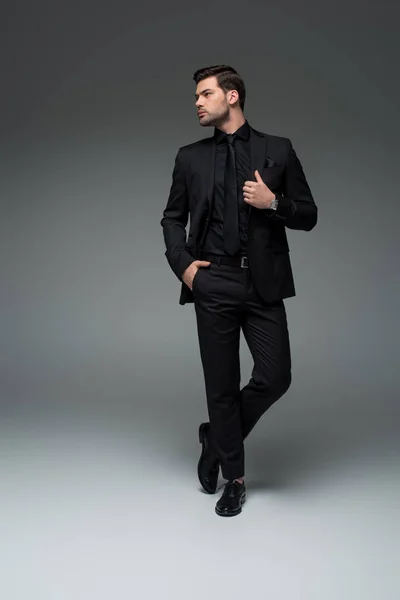 Jovem Homem Elegante Terno Preto Posando Cinza — Fotografia de Stock