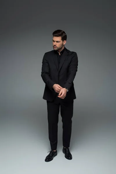 Stylish Man Black Suit Correcting His Wristwatch Grey — Stock Photo, Image
