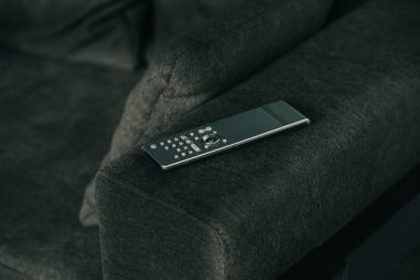 Uzaktan kumanda üzerindeki koyu gri kanepe