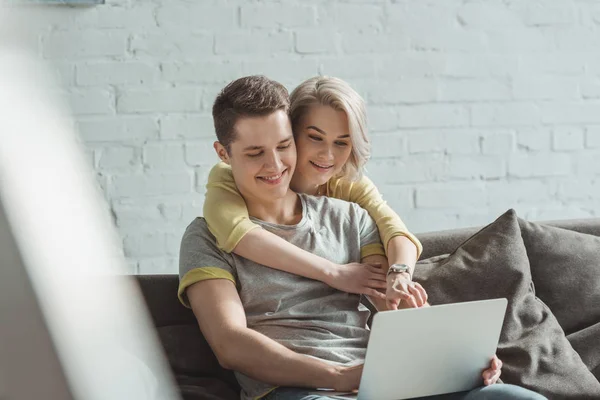 Novia Sonriente Abrazando Novio Apuntando Computadora Portátil Casa — Foto de Stock