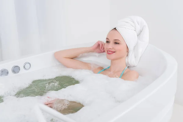 Mujer Sonriente Con Toalla Cabeza Relajante Baño Con Espuma Salón — Foto de Stock
