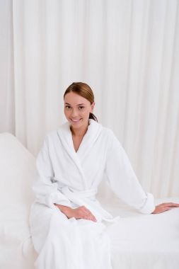 beyaz bornoz spa salonda oturan genç çekici kadın