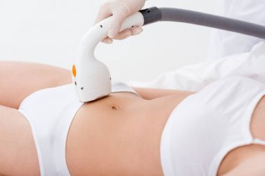 woman in underwear receiving laser hair removal procedure on stomach on salon clipart