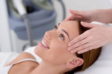 partial view of young woman getting head massage made by cosmetologist in salon clipart
