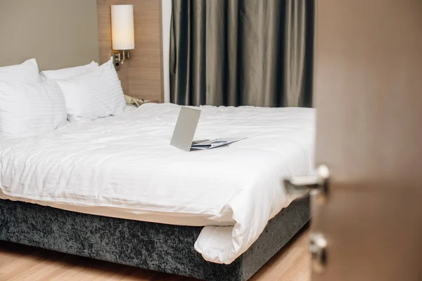 laptop on bed at modern hotel suite