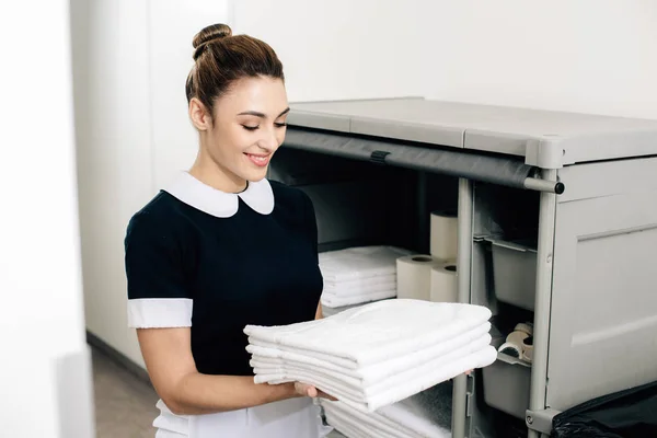 Young Happy Maid Uniform Taking Towels Shelf Housekeeping Cart — Stock Photo, Image