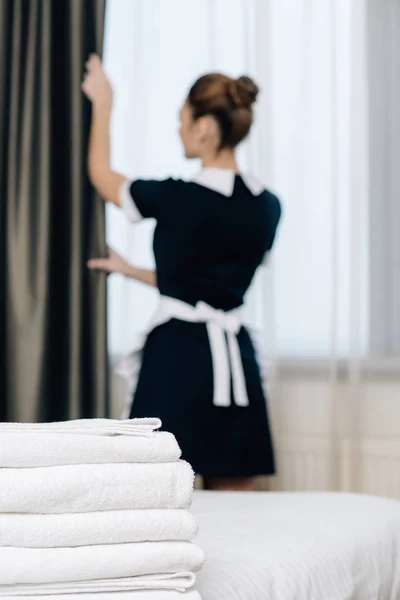 Young Maid Uniform Shutting Curtain Stack Clean Towels Standing Foreground — Stock Photo, Image