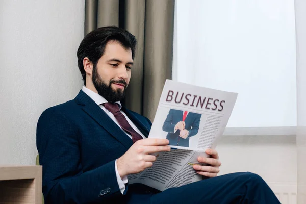 Χαμογελώντας Όμορφος Επιχειρηματίας Ανάγνωση Εφημερίδων Στο Δωμάτιο Του Ξενοδοχείου — Φωτογραφία Αρχείου
