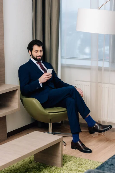 Homem Negócios Sorrindo Usando Smartphone Enquanto Sentado Poltrona — Fotografia de Stock Grátis