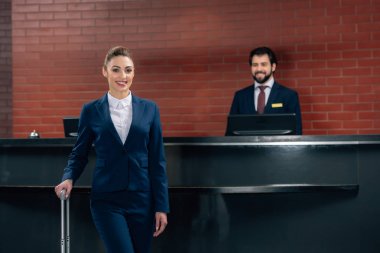 işkadını yönetici ile otel Resepsiyon sayaç önünde Bagaj ayakta ile gülümseyen