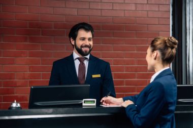 Müşteri o kasaya sözleşme imzalanması sırasında konuşurken otel resepsiyonist