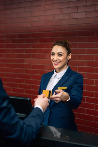 Jovem Recepcionista Hotel Feliz Tendo Cartão Crédito Cliente — Fotografia de Stock
