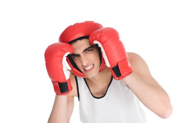 Skinny sportsman hiding face by hands in boxing gloves isolated on white clipart