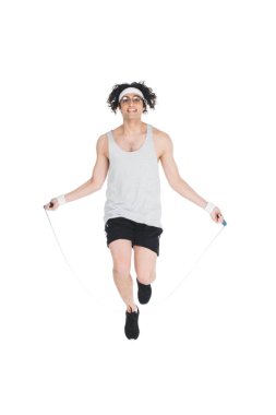 Young skinny sportsman in eyeglasses doing jump rope workout isolated on white clipart