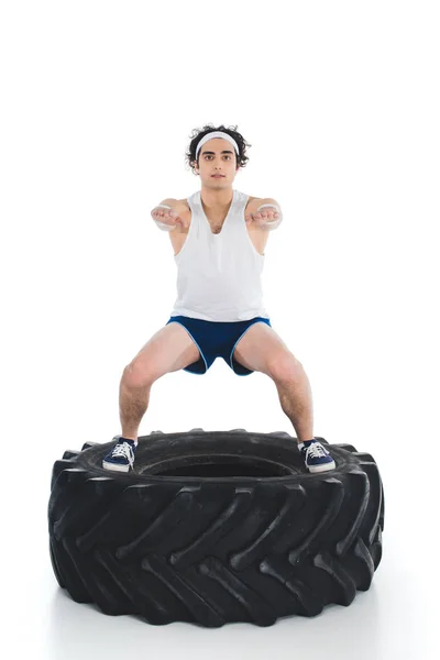 Mager Sportler Trainiert Auf Reifen Des Rades Isoliert Auf Weiß — kostenloses Stockfoto