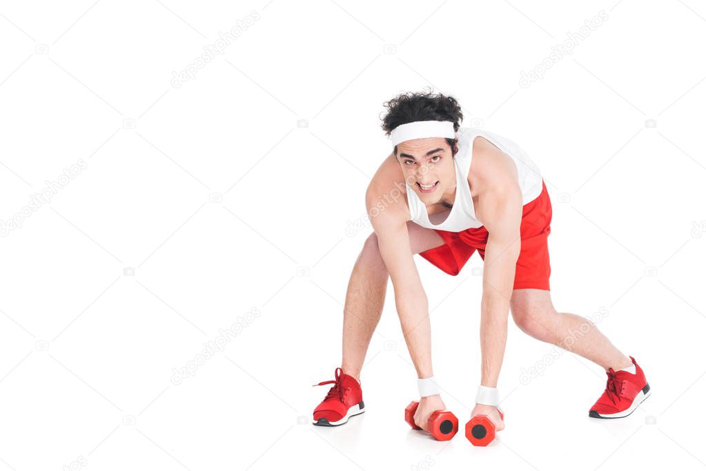 Young skinny man in jogger shoes and shorts with dumbbells isolated on white