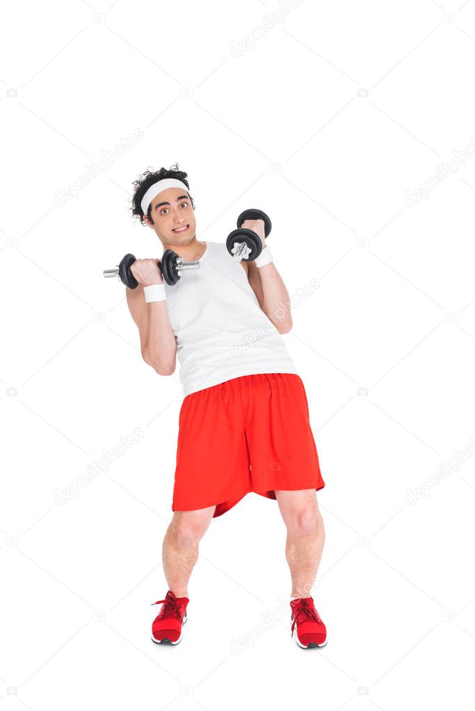 Thin man in headband exercising with dumbbells isolated on white
