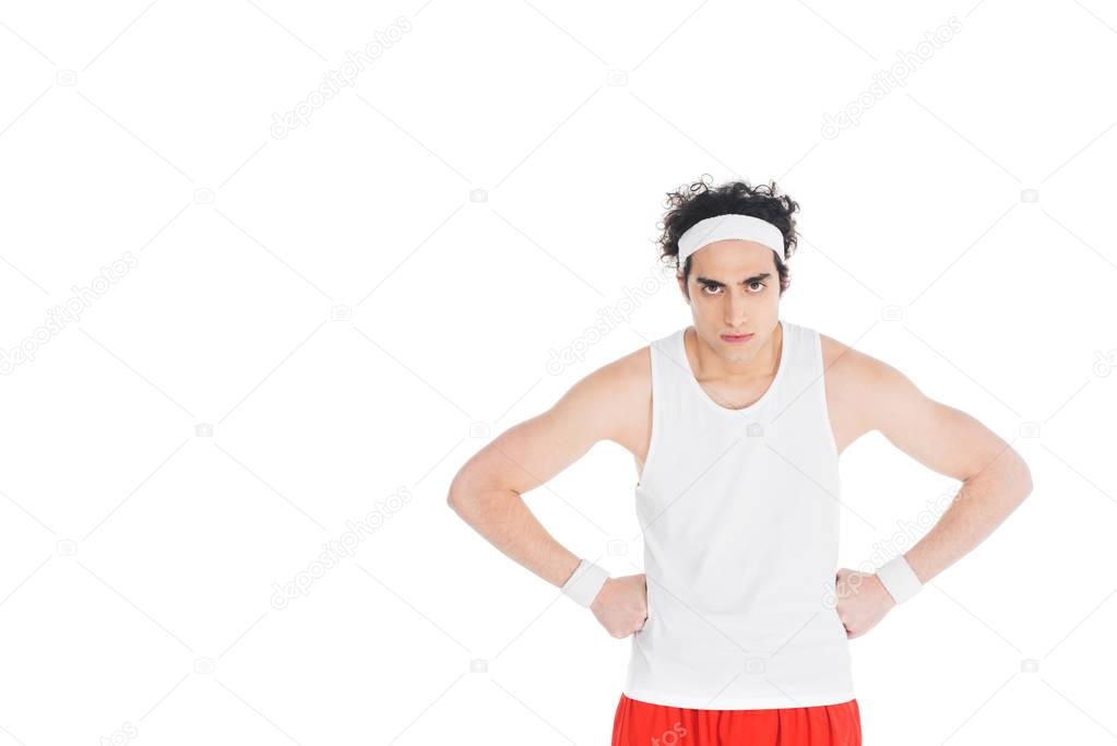 Thin serious sportsman with hands on waist isolated on white 