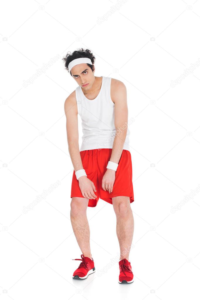 Young thin sportsman in shorts and jogging shoes isolated on white