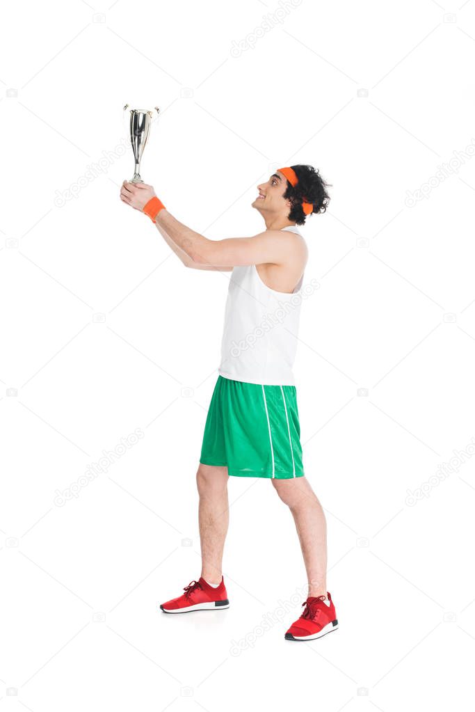 Profile of happy sportsman holding trophy isolated on white