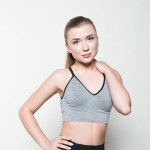 Junge Frau in Sportkleidung posiert isoliert auf weißem Grund