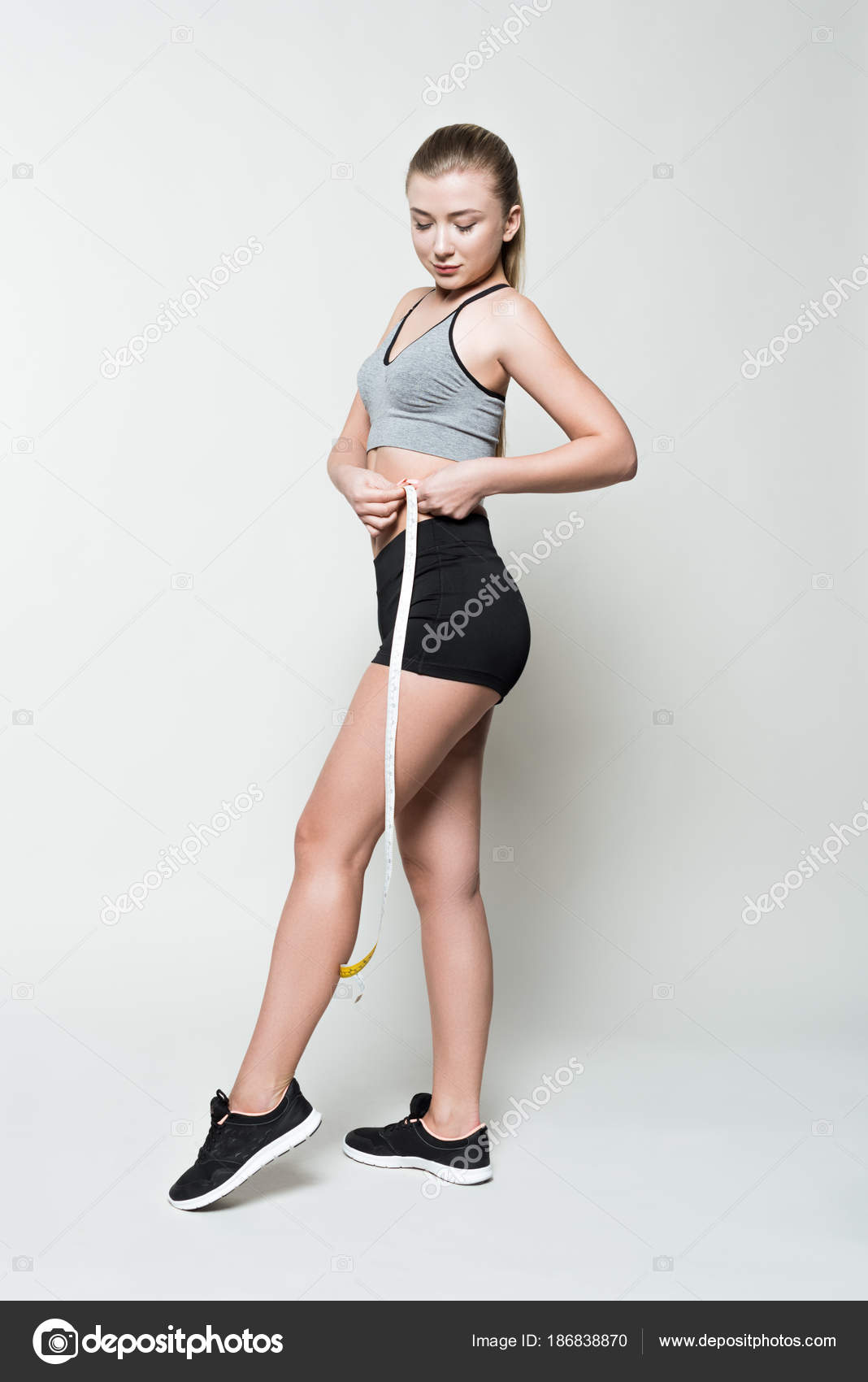 Young Girl Sports Clothes Measuring Herself Isolated White Stock