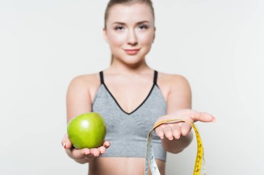 Elma ve elinde bir sportif kız beyaz izole bant ölçme yakından görmek