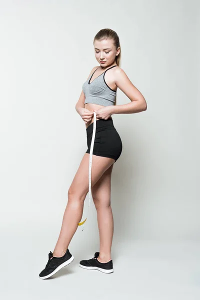 Молодая Девушка Спортивной Одежде Измеряющая Себя Изолированной Белом — стоковое фото