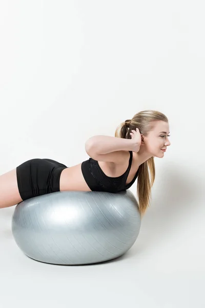 stock image Young fit girl on exercise ball isolated on white