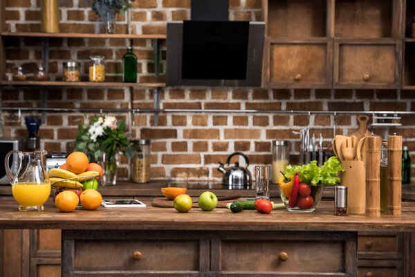 digital tablet, fresh fruits and vegetables on kitchen table
