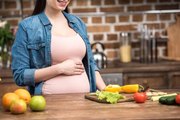 Tiro Cortado Sorrir Jovem Grávida Tocando Barriga Enquanto Cozinha — Fotografia de Stock