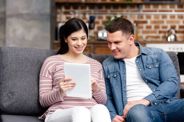 Pasangan Muda Hamil Tersenyum Menggunakan Tablet Digital Bersama Sama Rumah — Stok Foto