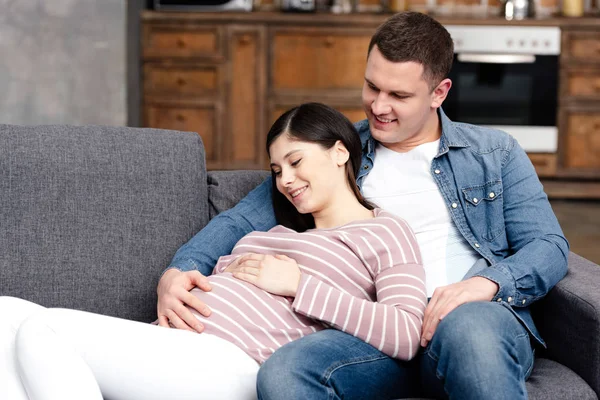 Happy Young Pregnant Couple Embracing Touching Belly Together Home — Stock Photo, Image