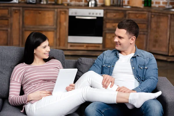 Feliz Joven Mirando Sonriente Esposa Embarazada Usando Tableta Digital Casa — Foto de Stock