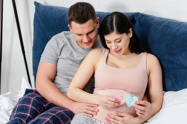 Happy Young Pregnant Couple Touching Tummy Holding Heart Shaped Cards — Stock Photo, Image