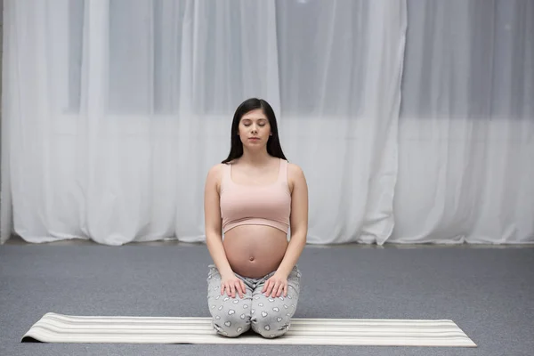 Femeie Gravidă Tânără Ochi Închiși Așezată Covor Yoga — Fotografie de stoc gratuită