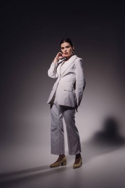 koyu zemin üzerinde poz beyaz elbiseli genç moda kadın